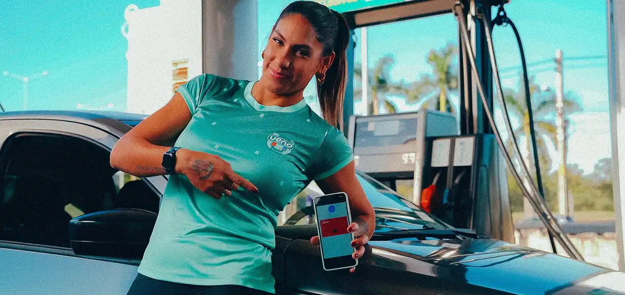 Mujer usando la app de ueno para realizar un pago móvil contactless en una estación de servicio.